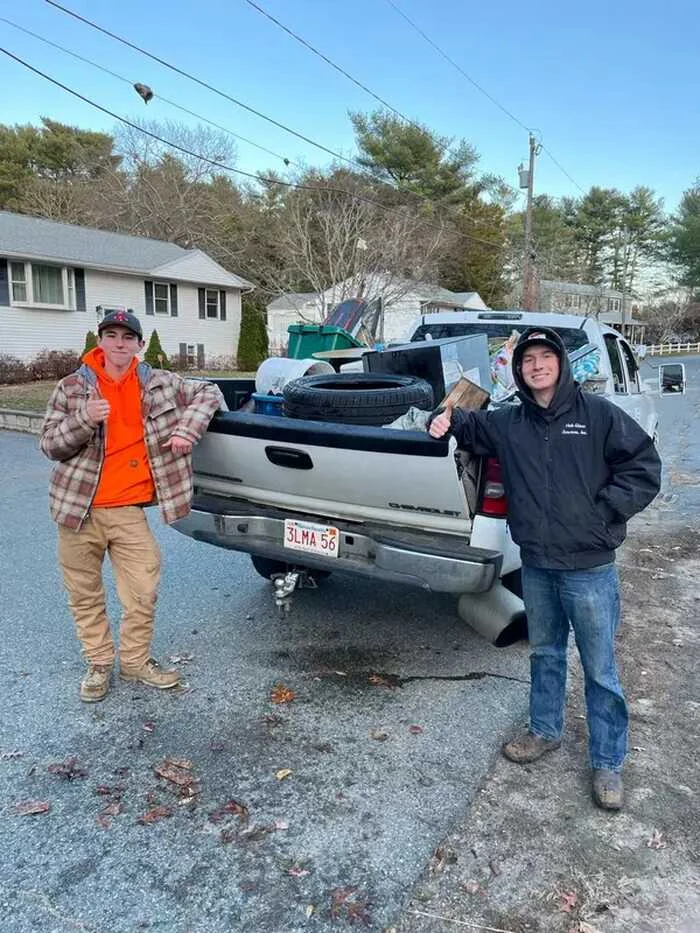 Two people beside a loaded pickup, shared by Pickups Junk Removal