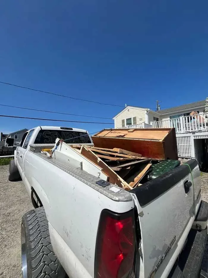 Furniture and materials in the bed of a white pickup